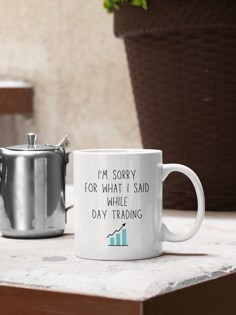 May include: White ceramic coffee mug with a black and blue graphic that says "I'm sorry for what I said while day trading" with an upward trending blue bar graph.