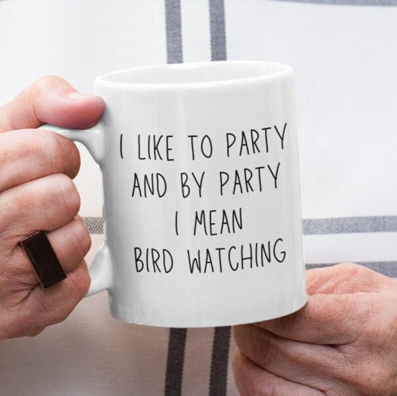 May include: White ceramic mug with black text that reads "I like to party and by party I mean bird watching".