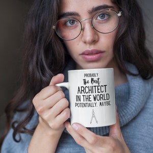 May include: White ceramic mug with black text that reads "Probably The Best Architect In The World Potentially. Maybe." and a black and white illustration of a compass.