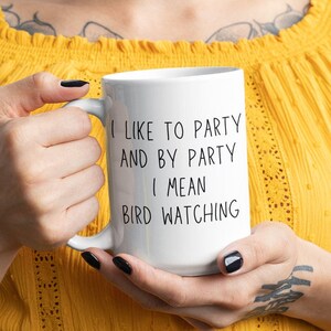 May include: White ceramic mug with black text that reads "I like to party and by party I mean bird watching".