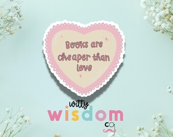 May include: Pink heart-shaped sticker with the text "Books are cheaper than love" and the words "witty wisdom co" below.