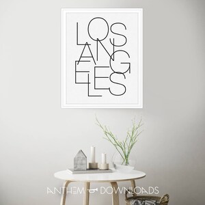 May include: A black and white framed print with the word "LOS ANGELES" written in a modern, geometric font.