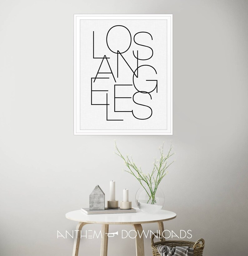 May include: A black and white framed print with the word "LOS ANGELES" written in a modern, geometric font.