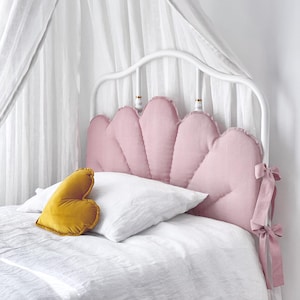 Puede incluir: Un letrero de madera rústico blanco con la palabra "Welcome" en un estilo manuscrito. El letrero tiene un aspecto envejecido y un elemento floral decorativo. El fondo es una textura de madera borrosa.