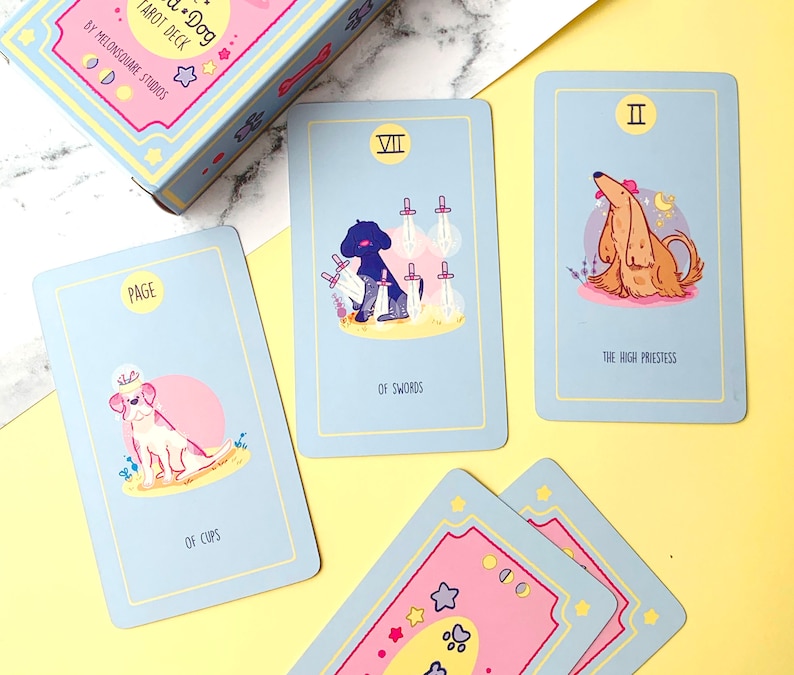Puede incluir: Un juego de cartas de tarot con ilustraciones de perros en varias poses. Las cartas son azules con bordes amarillos y muestran el texto "Dog Tarot Deck" y "By Melonsquare Studios".