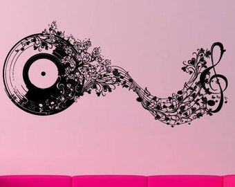 May include: Black vinyl record wall decal with musical notes and a treble clef design. The wall art is on a pink wall above a pink sofa and a pink vase with flowers. The musical notes flow from the record.