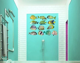 May include: A bathroom with a teal wall featuring a collection of colorful fish illustrations. A pink bathtub with ornate gold feet is centered in the room. White brick-style tiles and a wooden floor complete the design.