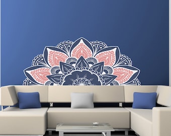May include: A white and pink mandala wall decal with a blue background. The decal is in the shape of a half circle and is placed above a beige sectional sofa with blue throw pillows.