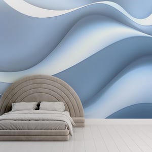 May include: A light gray bed frame with a curved headboard and a white bedspread. The bed is in a room with a blue and white abstract wall mural and a green plant in a white pot.