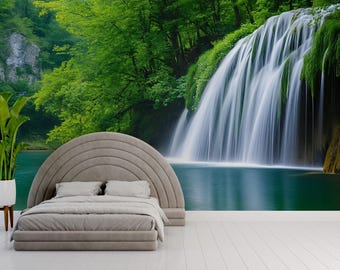 May include: A bedroom with a nature-themed mural featuring a waterfall cascading into a turquoise pool, surrounded by lush green trees. A gray bed with a curved headboard and a white plant in a pot complete the scene.