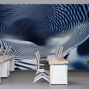 May include: An office interior featuring desks with computer monitors and chairs. The focal point is a large wall mural with a blue and white abstract design. A potted plant adds a touch of nature to the modern workspace.