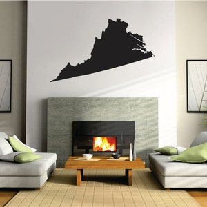May include: A living room interior with a fireplace, two couches, and a coffee table. A black silhouette of the state of Virginia is on the wall above the fireplace.