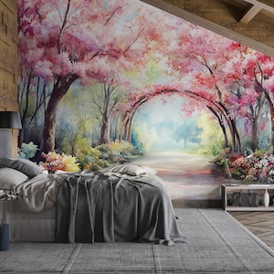 以下が含まれることがあります： カラフルな森の風景の壁画がある寝室。壁画は、ピンクの花が咲く木のアーチを通る小道を描いています。灰色の寝具と枕が付いたベッドが壁画の前にあります。