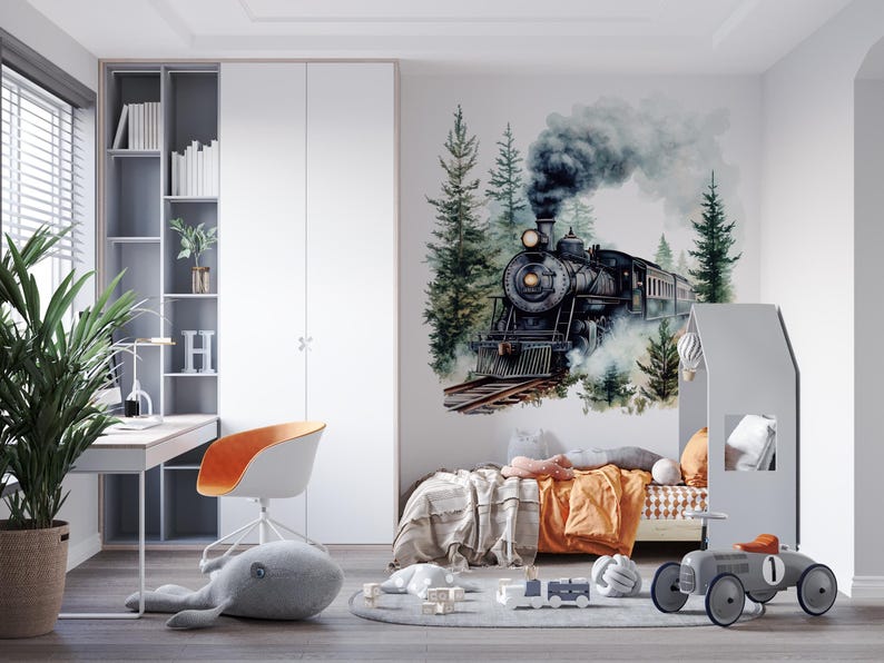 May include: A black and gray toy train engine with smoke coming out of the chimney, surrounded by green trees and a watercolor background. The train is on a bed with a gray headboard and orange bedding.