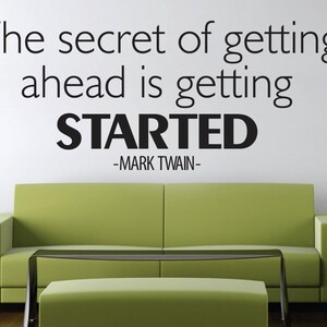 以下が含まれることがあります： マーク・トウェインの「成功への秘訣は始めること」という引用句が書かれた、やる気を起こさせるウォールアート。 黒い文字が白い壁に書かれており、緑色のソファとマッチするオットマンの上にあります。
