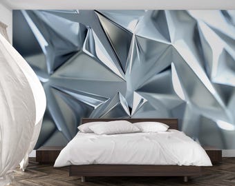 May include: A modern bedroom featuring a bed with white bedding and pillows. The headboard is a dark wood. The wall behind the bed has a large, abstract, geometric design in shades of silver and gray.