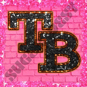 May include: Black glitter letters "TB" with gold outlines on a pink brick background.