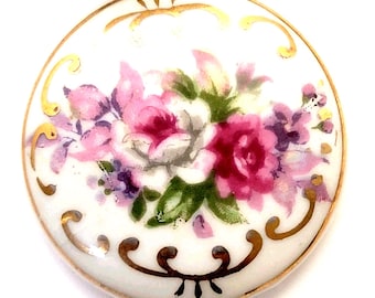 Caja de baratijas de porcelana japonesa vintage con detalles florales en oro rosa y base.