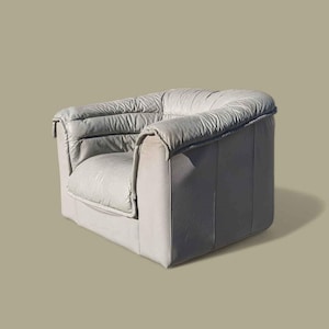 May include: A white leather armchair with a tufted design and a square shape.