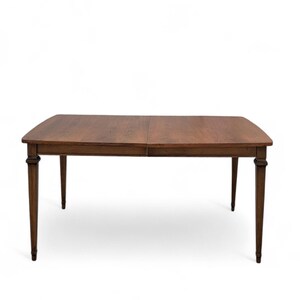May include: A rectangular wooden dining table with a rich brown finish. The table has a two-piece top and four slender, tapered legs. The table is approximately 72 inches long and 40 inches wide.