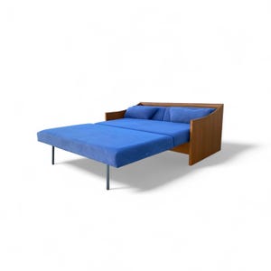 May include: A convertible sofa with a wooden frame and blue cushions. The sofa bed is partially extended, revealing a blue seating area. The design features a modern aesthetic with clean lines and a minimalist style.