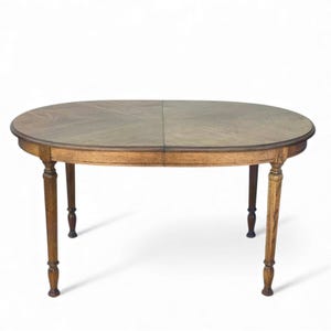 May include: Oval wooden dining table with a light brown finish. The tabletop features a patterned design and is supported by four turned legs. The table is a classic piece of furniture, suitable for a dining room or kitchen.