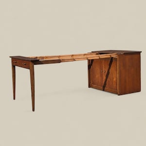 May include: A brown wooden extendable console table featuring a cabinet base with two doors and a single drawer on the opposite end. The table is shown in an extended position, revealing a slatted wooden support structure between the two ends.