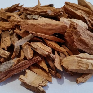 Puede incluir: Un montón de astillas de madera marrón, probablemente para ahumar carne o asar a la parrilla. Las astillas son de varios tamaños y formas, algunas son largas y delgadas, mientras que otras son cortas y gruesas.