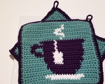 May include: Two teal crocheted pot holders with a purple crocheted coffee cup design. The pot holders have a loop for hanging.