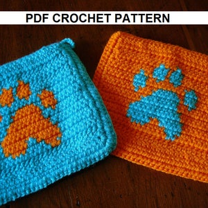 May include: Two crocheted squares with paw print designs. One square is blue with an orange paw print, and the other is orange with a blue paw print.