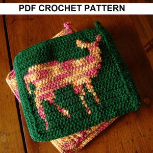 Puede incluir: Un posavasos de ganchillo verde con un diseño de ciervo en hilo rosa, naranja y amarillo. El posavasos está hecho con un punto texturizado.