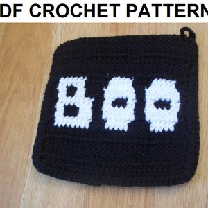 May include: Black crochet pot holder with a white crocheted "BOO" design.