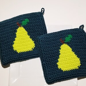 May include: Two dark teal crochet potholders with a bright yellow pear design. The pears have green leaves and brown stems. Each potholder has a small loop for hanging.
