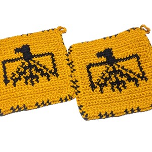 以下が含まれることがあります： 2つの正方形のかぎ針編み鍋つかみ。鍋つかみは黄色で、中央に黒い鳥のデザインがあります。縁は黒で縁取られています。各鍋つかみには、吊り下げ用の小さなループが付いています。