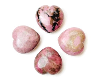May include: Four pink and black heart-shaped polished stones. The stones have a variety of patterns and textures.