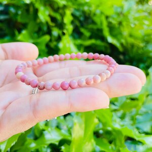 K&ouml;nnte beinhalten: Ein rosafarbenes Edelstein-Armband mit kleinen runden Perlen. Das Armband besteht aus nat&uuml;rlichen Steinen und ist ein wundersch&ouml;nes Accessoire f&uuml;r jeden Anlass.