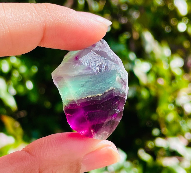 Pu&ograve; includere: Un cristallo di fluorite multicolore con sfumature di verde, viola e bianco. Il cristallo &egrave; grezzo e ha una forma naturale irregolare.