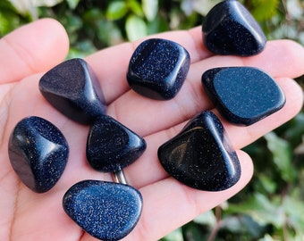 Puede incluir: Una colección de ocho piedras azules pulidas con arena. Las piedras son lisas y tienen un aspecto brillante y brillante.