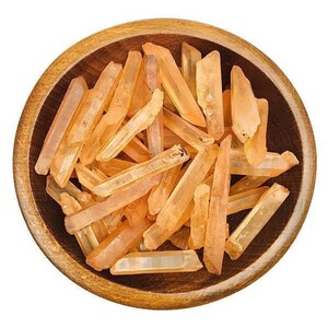 May include: A wooden bowl filled with a collection of orange quartz crystal points. The crystals are various sizes and shapes, with some being longer and thinner than others.