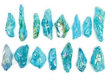 May include: A collection of 15 iridescent blue crystal points. The crystals are various sizes and shapes, with a light blue color and iridescent shimmer.