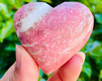 May include: A heart-shaped pink and white gemstone with a swirling pattern.