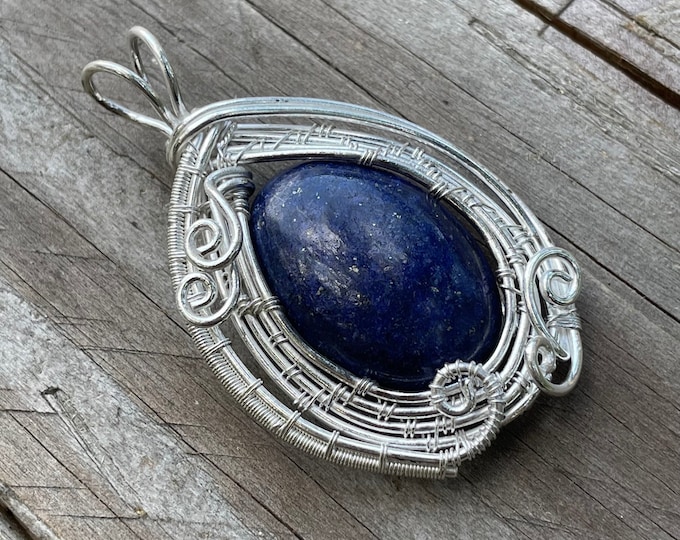 Pendant woven in 925 silver thread with a boho style lapis lazuli cabochon.