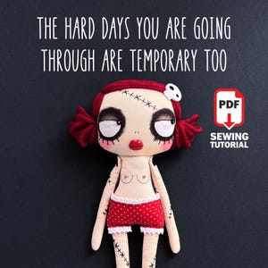 Könnte beinhalten: Eine handgefertigte Puppe mit roten Zöpfen, aufgenähten Gesichtszügen und roten Shorts mit Polka Dots. Der Text "THE HARD DAYS YOU ARE GOING THROUGH ARE TEMPORARY TOO" wird über der Puppe angezeigt. Ein PDF-Nähanleitungs-Symbol befindet sich im Bild.