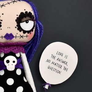 dark cute gothic fabric doll detail showing arm holding paper balloon with quote “Love is the answer no matter the question” from sewing tutorial with printable PDF pattern