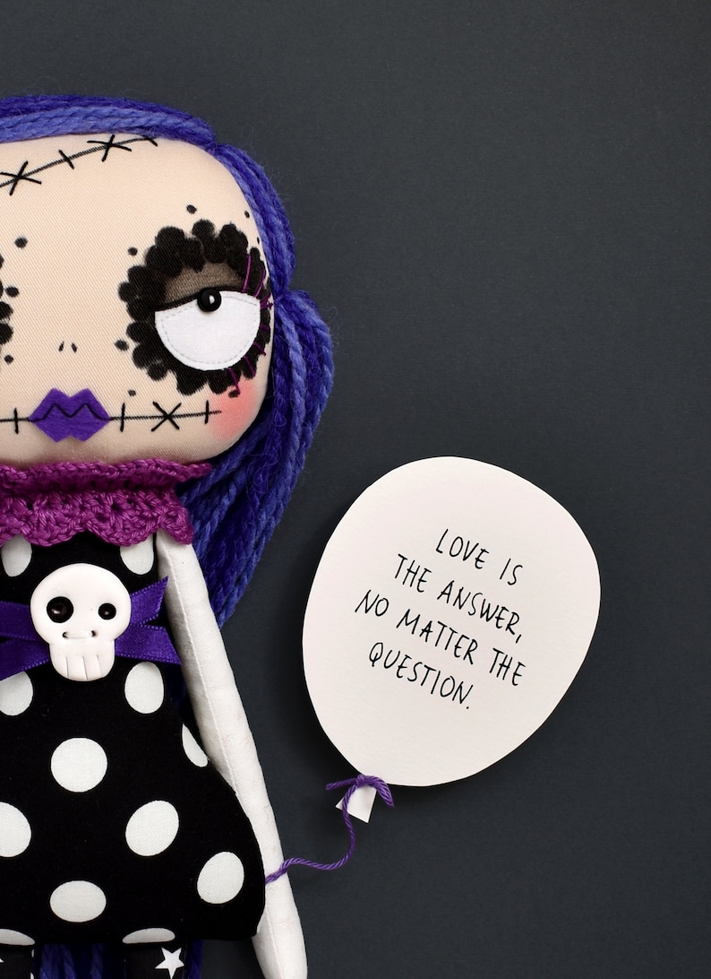 dark cute gothic fabric doll detail showing arm holding paper balloon with quote “Love is the answer no matter the question” from sewing tutorial with printable PDF pattern