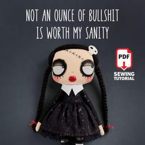 Puede incluir: Una muñeca hecha a mano con un vestido negro, cuello blanco y largas trenzas negras. La muñeca tiene una cicatriz cosida en la frente y un accesorio para el pelo de calavera. El texto "NOT AN OUNCE OF BULLSHIT IS WORTH MY SANITY" está encima de la muñeca.