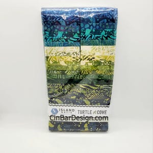 May include: A pack of 20 fabric strips in a variety of blue, green, and yellow batik prints. The fabric strips are packaged in clear plastic and labeled "Island Batik Turtle Cove CinBarDesign.com".