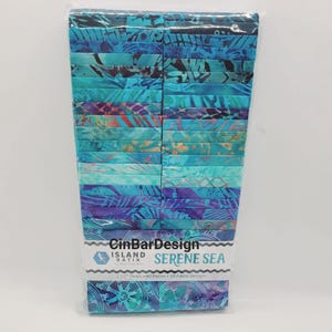 May include: A stack of 40 fabric strips in a clear plastic wrapper, labeled CinBarDesign Island Batik Serene Sea, featuring 20 fabric designs. Each strip measures 2 1/2 inches wide and displays various shades of blue, teal, and purple patterns.