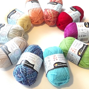 Può includere: Un assortimento arcobaleno di 10 gomitoli di lana in vari colori, tra cui rosso, arancione, giallo, verde, blu, viola e beige. Ogni gomitolo di lana è etichettato "Schachenmayr Baby Smiles Merino Wool" con il peso e la lunghezza della lana.