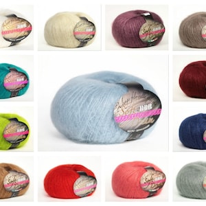 May include: A collection of skeins of soft, fluffy yarn in various colors, including white, beige, purple, gray, teal, green, light blue, navy, brown, red, pink, and gray. The yarn is labeled "Soft Silk" and "BBB Denim".